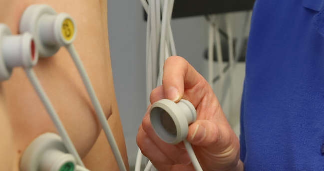 Eine Mitarbeiterin beim Anlegen eines EKG